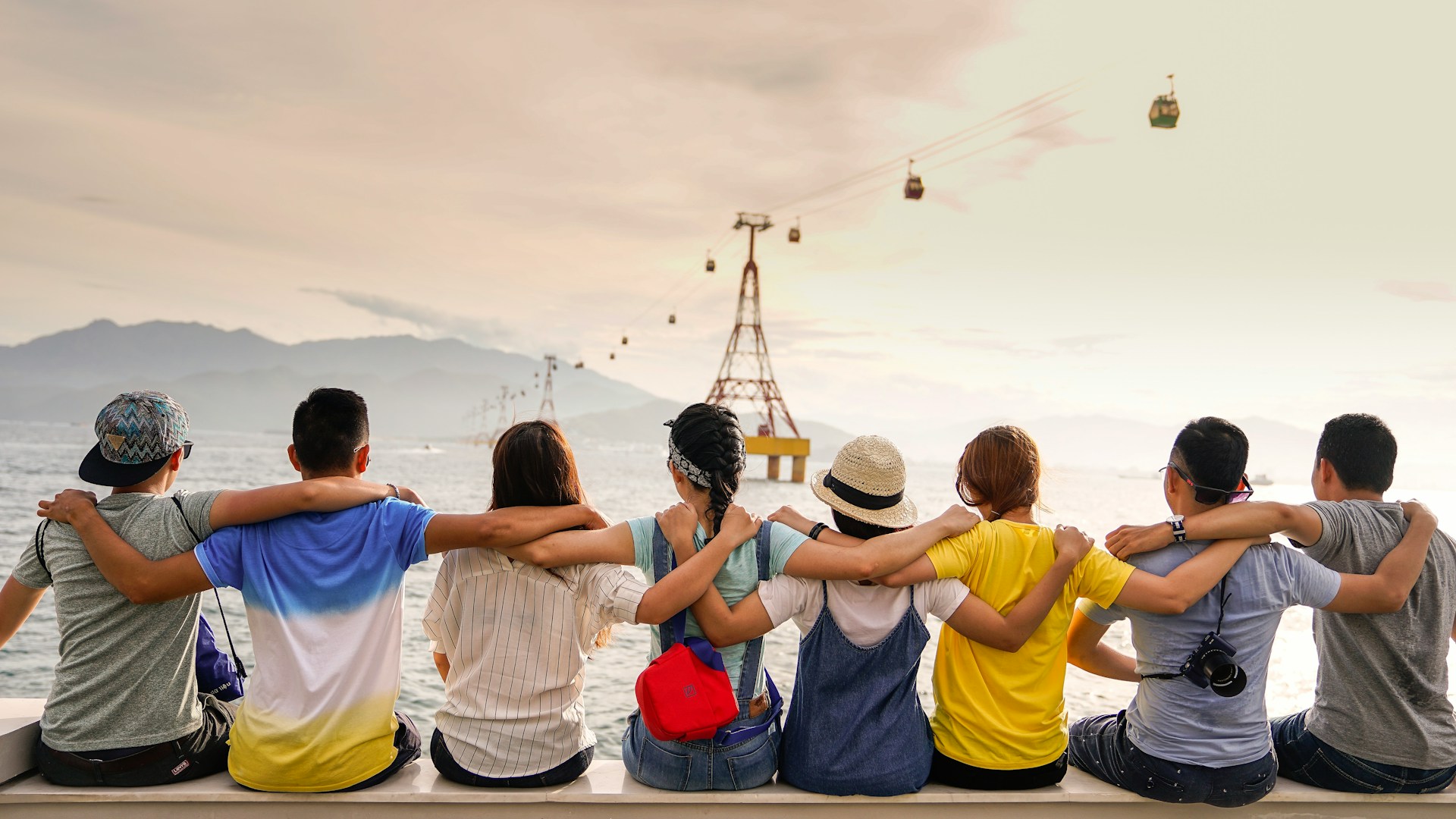 A group of people sitting together while holding hands across their backs.